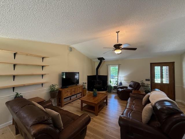 16051 Mo 142, Thayer, MO 65791 - living room with a textured ceiling, a wood stove, a ceiling fan, light wood-type flooring, and lofted ceiling