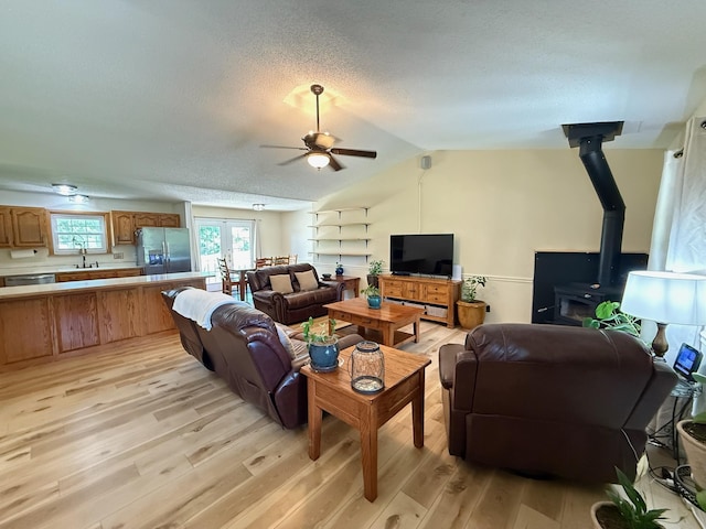 16051 Mo 142, Thayer, MO 65791 - living area featuring ceiling fan, light wood-type flooring, a wood stove, a textured ceiling, and lofted ceiling