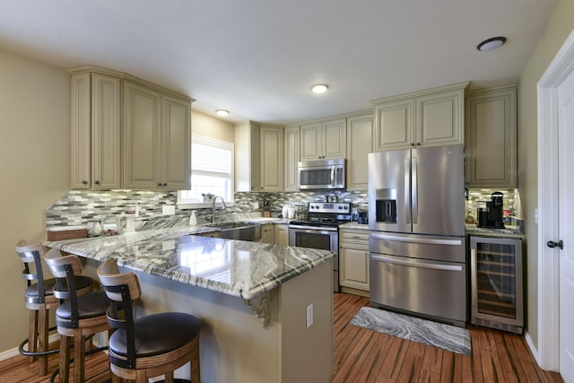 440 Spring Meadow Pkwy, Branson, MO 65616 - kitchen with appliances with stainless steel finishes, cream cabinets, beverage cooler, a peninsula, and recessed lighting