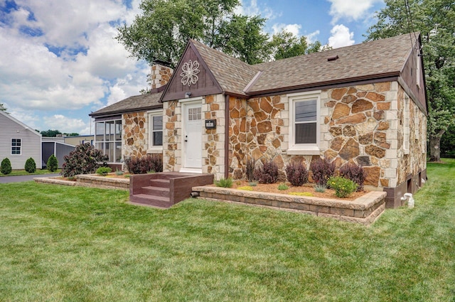 1841 E Dale St, Springfield, MO 65803 - tudor home featuring stone siding, a shingled roof, a chimney, and a front yard