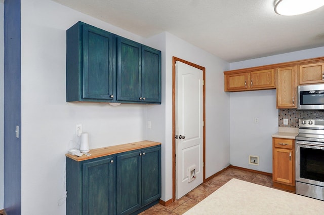 1603 W Robin St, Ozark, MO 65721 - kitchen featuring stainless steel appliances, light countertops, backsplash, and blue cabinetry