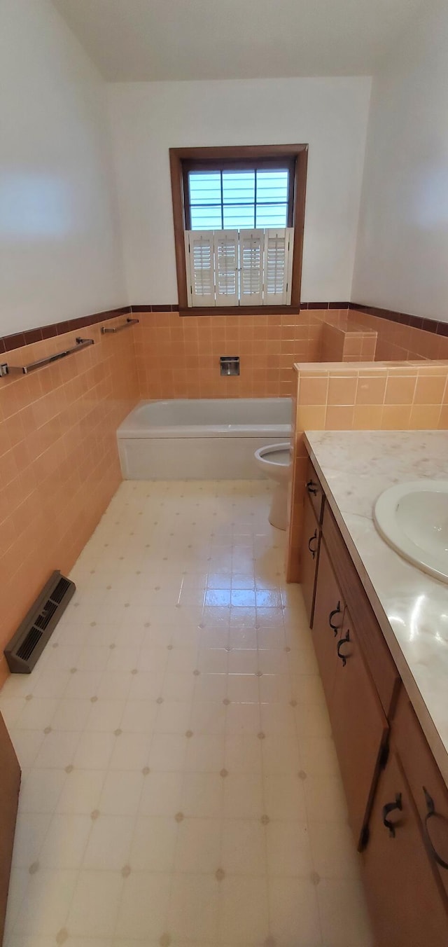 918 E Mcgee St, Springfield, MO 65807 - bathroom featuring tile walls, vanity, a garden tub, and a wainscoted wall