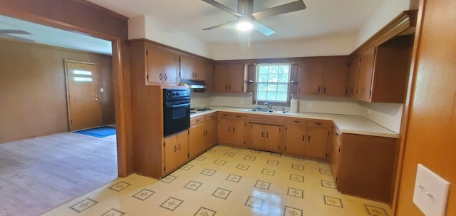 918 E Mcgee St, Springfield, MO 65807 - kitchen with oven, under cabinet range hood, ceiling fan, light countertops, and light flooring