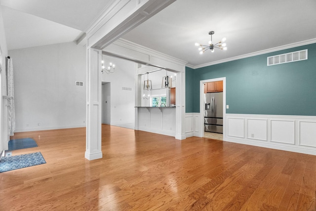 253 Cedar Glade Dr, Branson West, MO 65737 - unfurnished living room with a chandelier, ornamental molding, light wood-style flooring, and a wainscoted wall