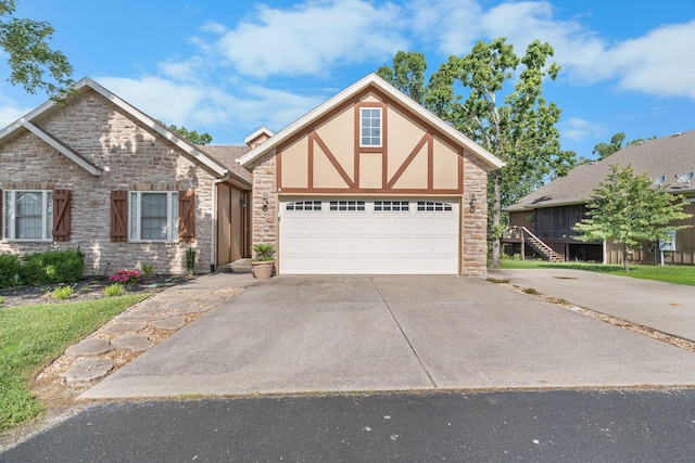 253 Cedar Glade Dr, Branson West, MO 65737 - tudor home featuring concrete driveway, stone siding, a garage, and stucco siding