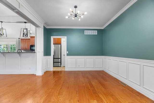 253 Cedar Glade Dr, Branson West, MO 65737 - unfurnished dining area with a chandelier, light wood-type flooring, wainscoting, and ornamental molding
