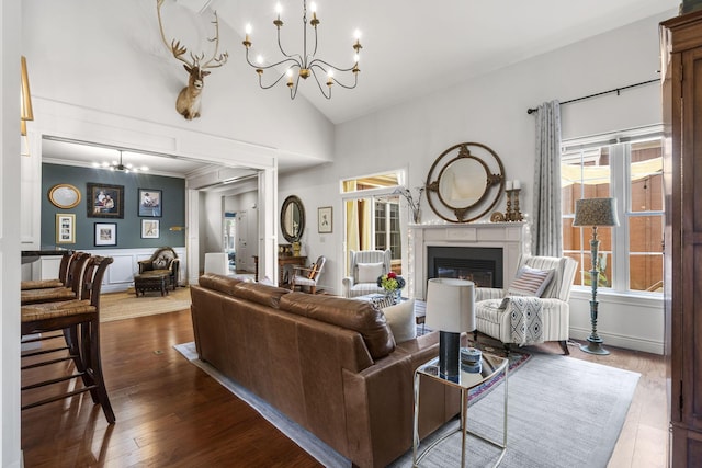 253 Cedar Glade Dr, Branson West, MO 65737 - living area featuring a chandelier, a glass covered fireplace, wood finished floors, a decorative wall, and high vaulted ceiling
