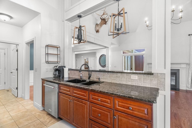 253 Cedar Glade Dr, Branson West, MO 65737 - kitchen with stainless steel dishwasher, backsplash, dark stone countertops, a high ceiling, and brown cabinets