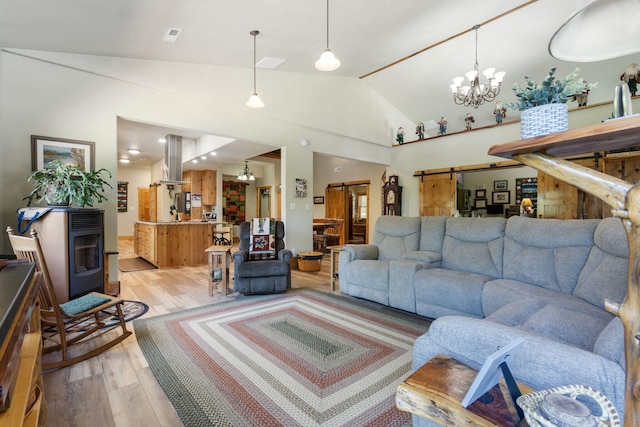 26474 Kings River Rd, Shell Knob, MO 65747 - living room featuring a chandelier, lofted ceiling, light wood finished floors, and a barn door
