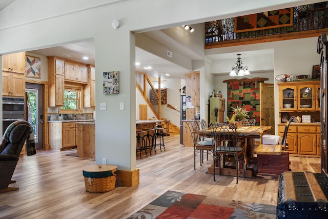 26474 Kings River Rd, Shell Knob, MO 65747 - dining area with light wood finished floors, stairway, and a chandelier