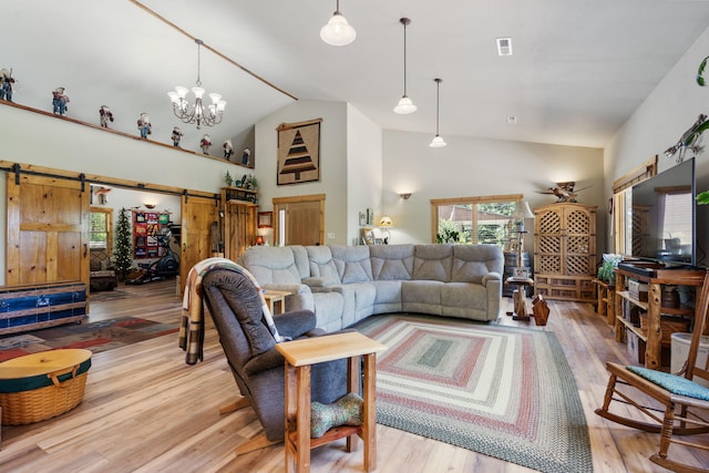 26474 Kings River Rd, Shell Knob, MO 65747 - living room with a barn door, wood finished floors, high vaulted ceiling, and a chandelier