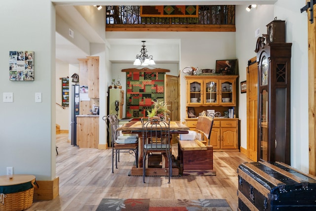 26474 Kings River Rd, Shell Knob, MO 65747 - dining space featuring a barn door, light wood-style flooring, and a chandelier