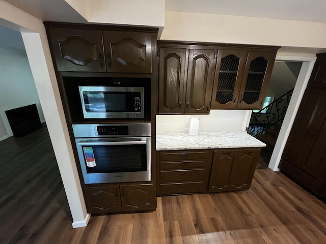 805 E 13th St, Cassville, MO 65625 - kitchen with appliances with stainless steel finishes, dark wood-style flooring, dark brown cabinets, and glass insert cabinets