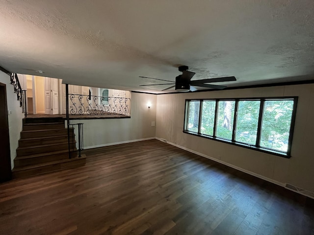 805 E 13th St, Cassville, MO 65625 - unfurnished living room featuring ceiling fan, dark wood-type flooring, stairs, and a textured ceiling