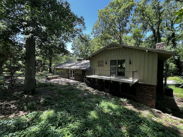 805 E 13th St, Cassville, MO 65625 - view of property exterior featuring a chimney, board and batten siding, a patio, and a balcony