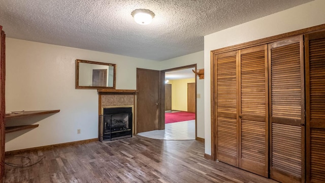 619 9th St, Thayer, MO 65791 - unfurnished living room with wood finished floors, a fireplace, and a textured ceiling