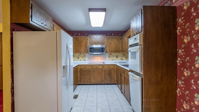 619 9th St, Thayer, MO 65791 - kitchen with white appliances, light countertops, light tile patterned flooring, brown cabinetry, and wallpapered walls