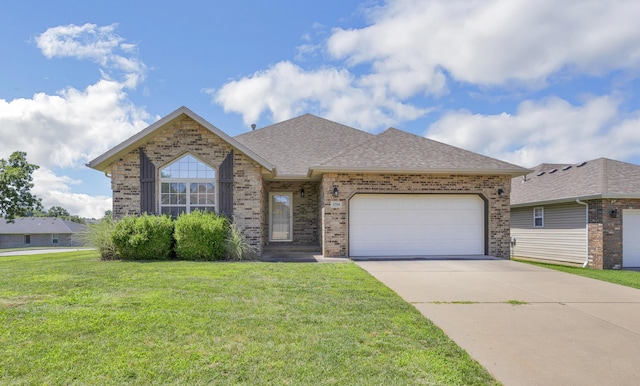 3790 W Rockwood St, Springfield, MO 65807 - view of front facade with brick siding, an attached garage, driveway, a front yard, and roof with shingles