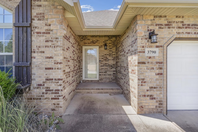 3790 W Rockwood St, Springfield, MO 65807 - doorway to property featuring brick siding, a shingled roof, and a garage