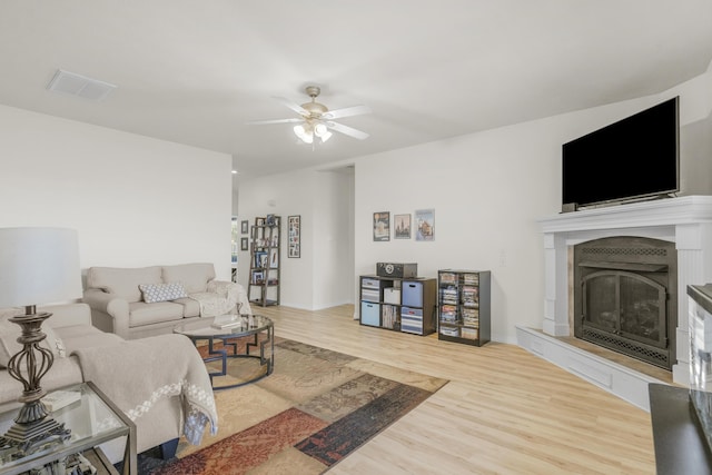 3790 W Rockwood St, Springfield, MO 65807 - living area featuring wood finished floors, a fireplace with raised hearth, and a ceiling fan