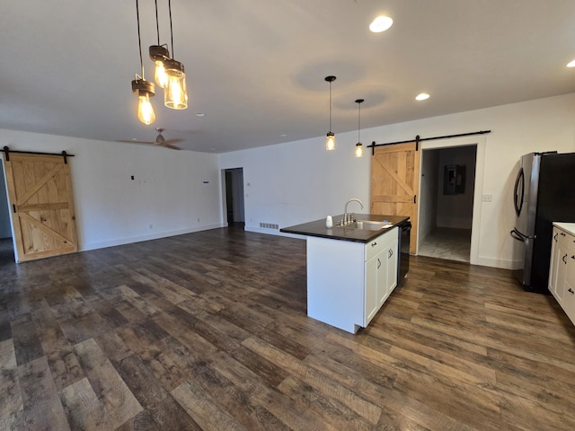 24136 Lazy Daze Ln, Wheatland, MO 65779 - kitchen featuring a barn door, freestanding refrigerator, dark countertops, dark wood-type flooring, and recessed lighting
