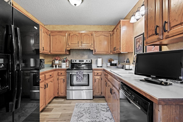 1617 Alexandra Dr, Carthage, MO 64836 - kitchen featuring black appliances, light countertops, light wood finished floors, a textured ceiling, and brown cabinetry