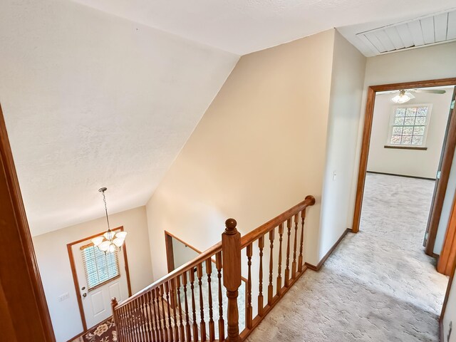 1617 Alexandra Dr, Carthage, MO 64836 - hallway featuring an upstairs landing, light carpet, vaulted ceiling, and a chandelier