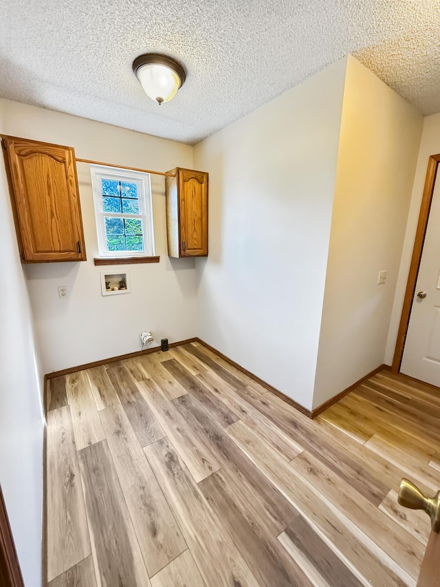 1617 Alexandra Dr, Carthage, MO 64836 - laundry room featuring cabinet space, washer hookup, a textured ceiling, and light wood-style flooring