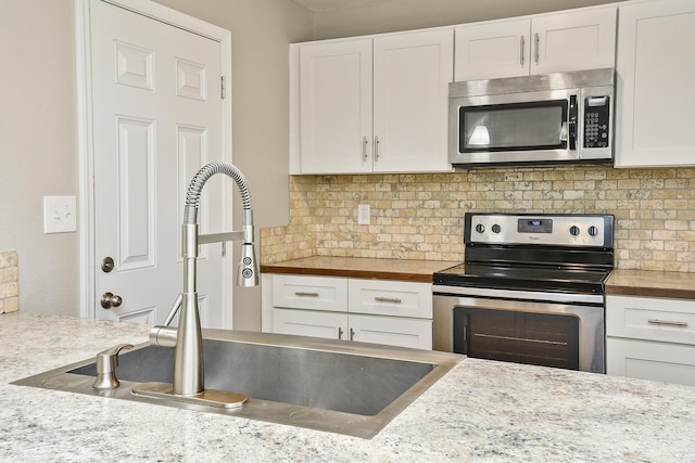 3539 S Walnut Hill Dr, Springfield, MO 65807 - kitchen with stainless steel appliances, white cabinets, backsplash, and butcher block countertops