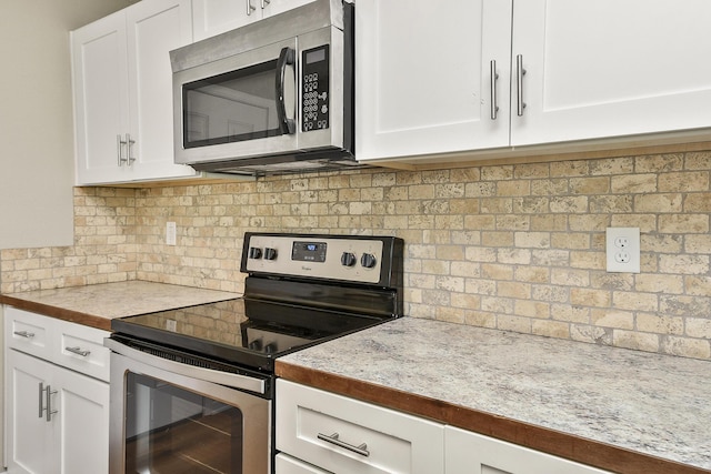 3539 S Walnut Hill Dr, Springfield, MO 65807 - kitchen with appliances with stainless steel finishes, white cabinets, decorative backsplash, and light countertops