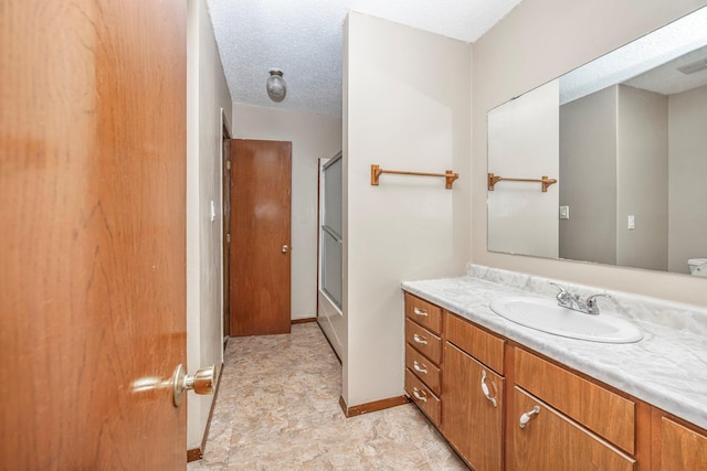 1016 S Lexington Ave, Springfield, MO 65802 - bathroom featuring vanity, combined bath / shower with glass door, and a textured ceiling