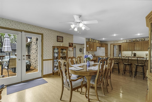3416 S Barnes Ave, Springfield, MO 65804 - dining area with wallpapered walls, a ceiling fan, light wood-style flooring, french doors, and wainscoting