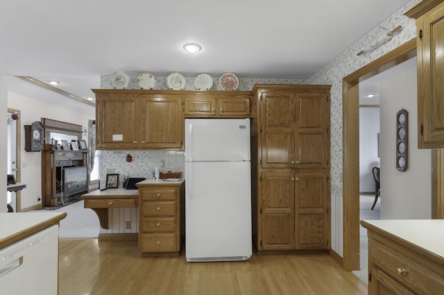 3416 S Barnes Ave, Springfield, MO 65804 - kitchen featuring white appliances, wallpapered walls, light wood-style floors, brown cabinetry, and light countertops