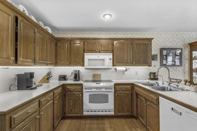 3416 S Barnes Ave, Springfield, MO 65804 - kitchen with white appliances, wallpapered walls, light countertops, wood finished floors, and brown cabinets