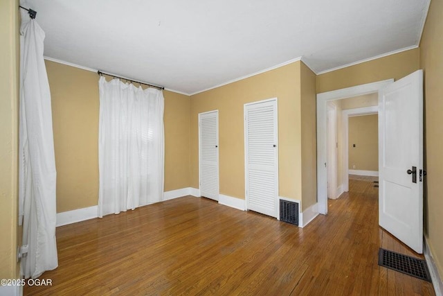 802 Hampton Pl, Joplin, MO 64801 - unfurnished bedroom with wood finished floors, crown molding, and multiple closets