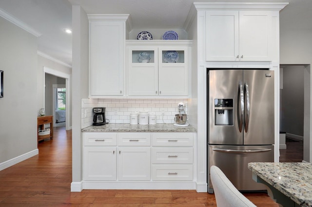 914 W Lorenza Dr, Nixa, MO 65714 - kitchen with stainless steel fridge, crown molding, decorative backsplash, white cabinetry, and light stone countertops