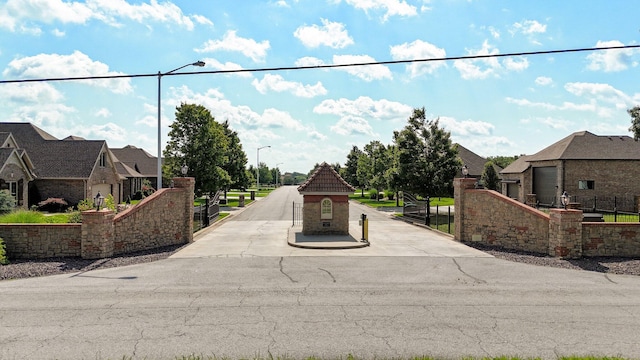 914 W Lorenza Dr, Nixa, MO 65714 - view of asphalt road featuring street lighting, a residential view, a gate, and a gated entry