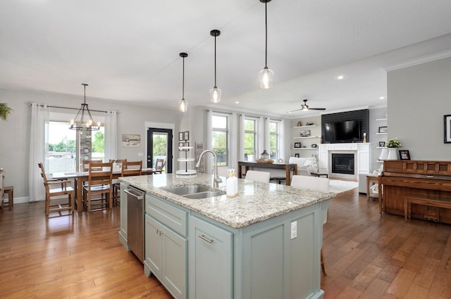 914 W Lorenza Dr, Nixa, MO 65714 - kitchen with a glass covered fireplace, stainless steel dishwasher, a ceiling fan, light wood-style flooring, and an island with sink