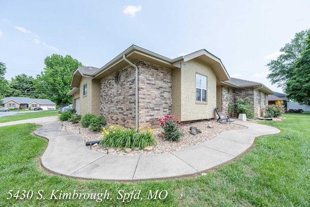 5430 S Kimbrough Ave, Springfield, MO 65810 - view of side of property featuring a yard, stucco siding, and brick siding