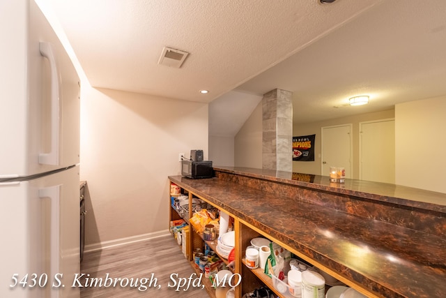5430 S Kimbrough Ave, Springfield, MO 65810 - indoor dry bar with freestanding refrigerator, wood finished floors, and a textured ceiling