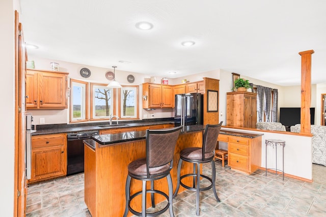 6585 N Farm Rd 61, Walnut Grove, MO 65770 - kitchen featuring black dishwasher, freestanding refrigerator, dark countertops, a kitchen bar, and a kitchen island