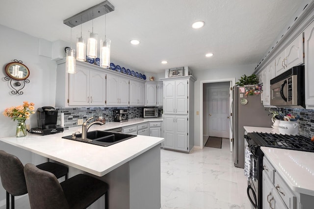715 W Wasson St, Nixa, MO 65714 - kitchen featuring stainless steel microwave, black gas stove, a peninsula, light marble finish flooring, and a breakfast bar