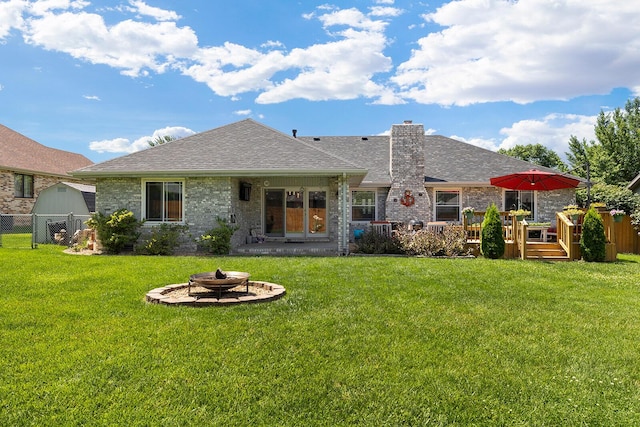 715 W Wasson St, Nixa, MO 65714 - back of property with a fire pit, a wooden deck, a chimney, roof with shingles, and brick siding