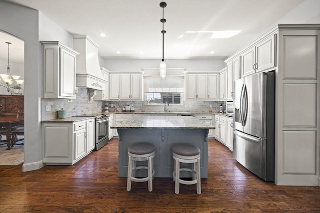 2741 Summit Dr, Joplin, MO 64804 - kitchen featuring appliances with stainless steel finishes, custom range hood, a chandelier, a center island, and backsplash