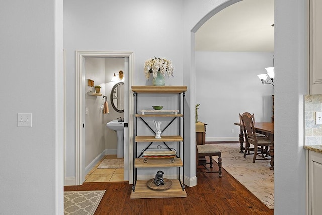 2741 Summit Dr, Joplin, MO 64804 - hall featuring arched walkways, wood finished floors, and a chandelier