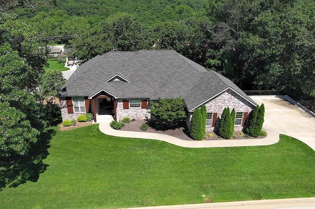 2741 Summit Dr, Joplin, MO 64804 - single story home with stone siding, a view of trees, a front lawn, and driveway