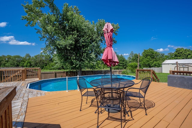 1035 Scenic View Rd, Ozark, MO 65721 - view of pool with a wooden deck, a fenced backyard, outdoor dining area, view of scattered trees, and an outbuilding