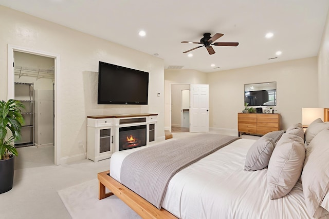 1035 Scenic View Rd, Ozark, MO 65721 - bedroom with a walk in closet, recessed lighting, a glass covered fireplace, ceiling fan, and light colored carpet