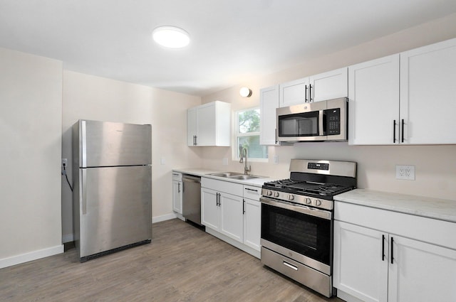 2131 N Pickwick Ave, Springfield, MO 65803 - kitchen with appliances with stainless steel finishes, light wood-type flooring, and white cabinets
