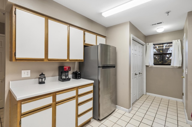 350 Wildwood Dr S Unit 31, Branson, MO 65616 - kitchen with freestanding refrigerator, light countertops, white cabinets, and light tile patterned floors